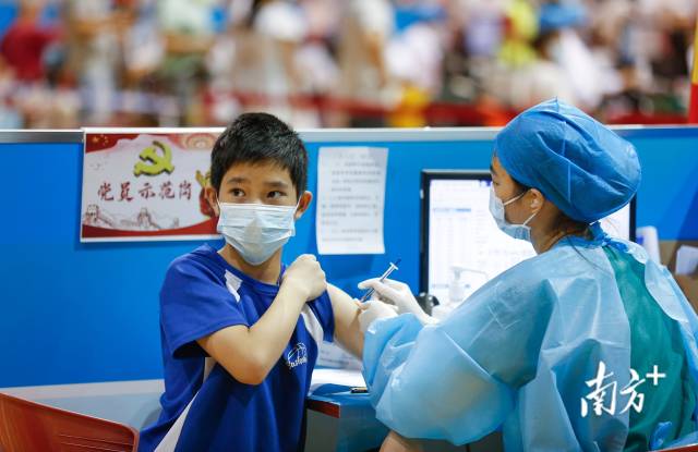 在中山市体育馆新冠疫苗临时接种点，医护人员为学生接种疫苗。